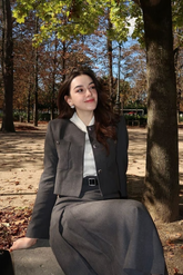 a lady in a white shirt and a grey jacket and skirt two-piece set